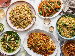 An overhead image of table set with various salad platters, piled high with vegetables.