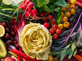 Beautiful produce, like bright red tomatoes, brilliant apples and squash, herbs and a cabbage, lay in an artfully arranged jumble.