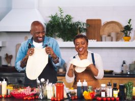 William Stanford Davis and Quinta Brunson stand at a kitchen counter full of ingredients.