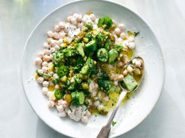 An overhead image of chickpeas and cucumbers in a creamy sauce.