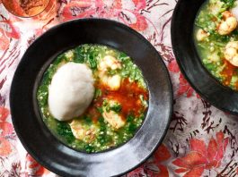 A deeply green soup studded with shrimp in a Dutch oven.