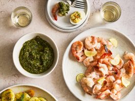 A summery spread of shrimp cocktail, tomato-potato salad and deviled eggs.