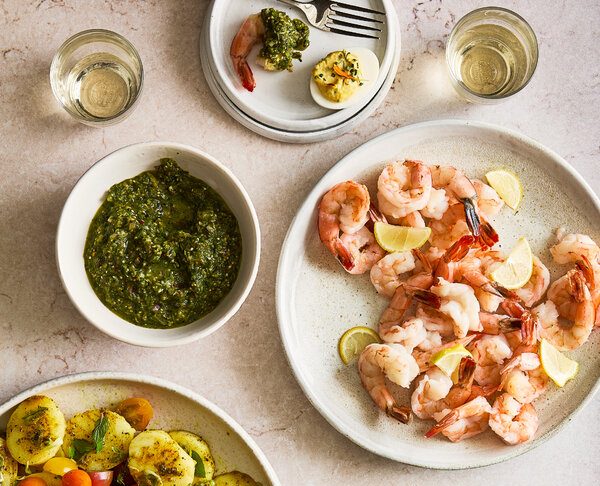 A summery spread of shrimp cocktail, tomato-potato salad and deviled eggs.