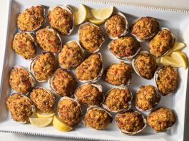 An overhead image of three stuffed clams on a plate.