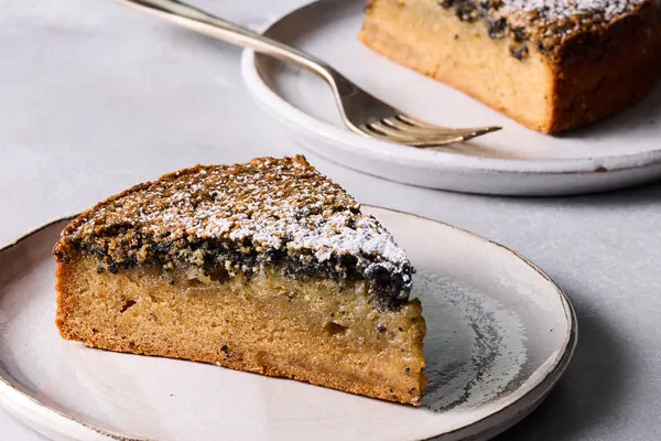 A side image of a cake with a layer of black sesame on top.