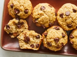 8 Easy, One-Bowl Muffins You Can Make in Under and Hour An overhead image of half a dozen banana chocolate chip muffins. One of the muffins is torn in half.