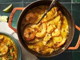 An overhead image of a Dutch oven filled with ebbeh, a seafood-cassava stew.
